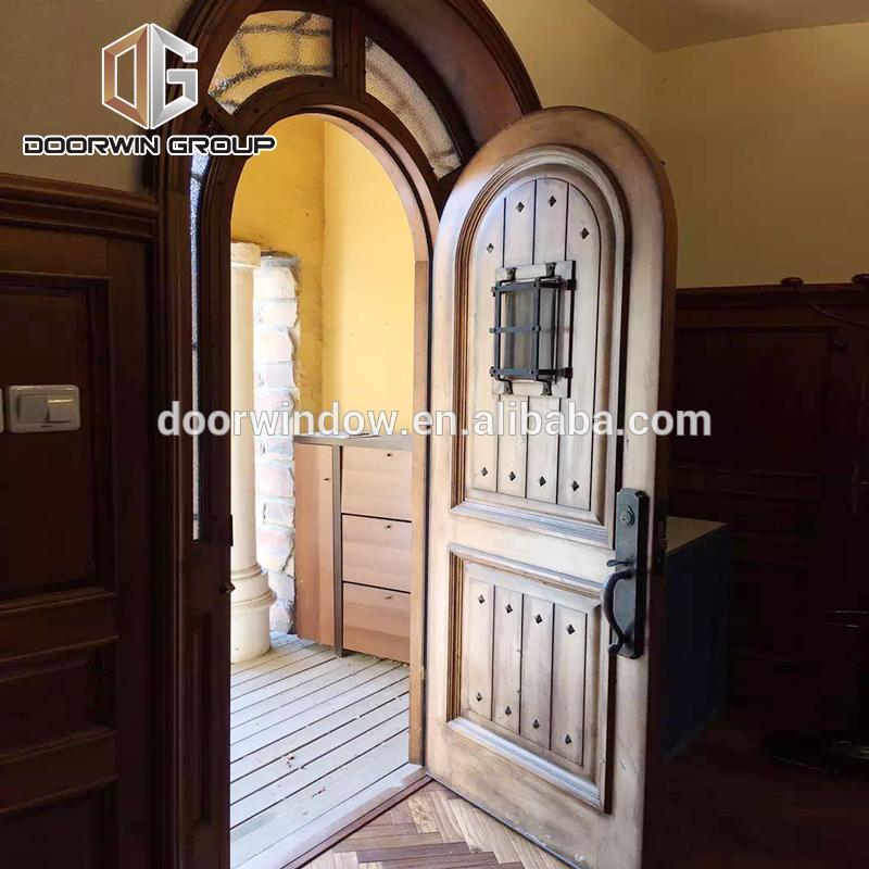 DOORWIN 2021Church gate style design exterior wood front doors with top carving glass entry door with side lite rustic door by Doorwin