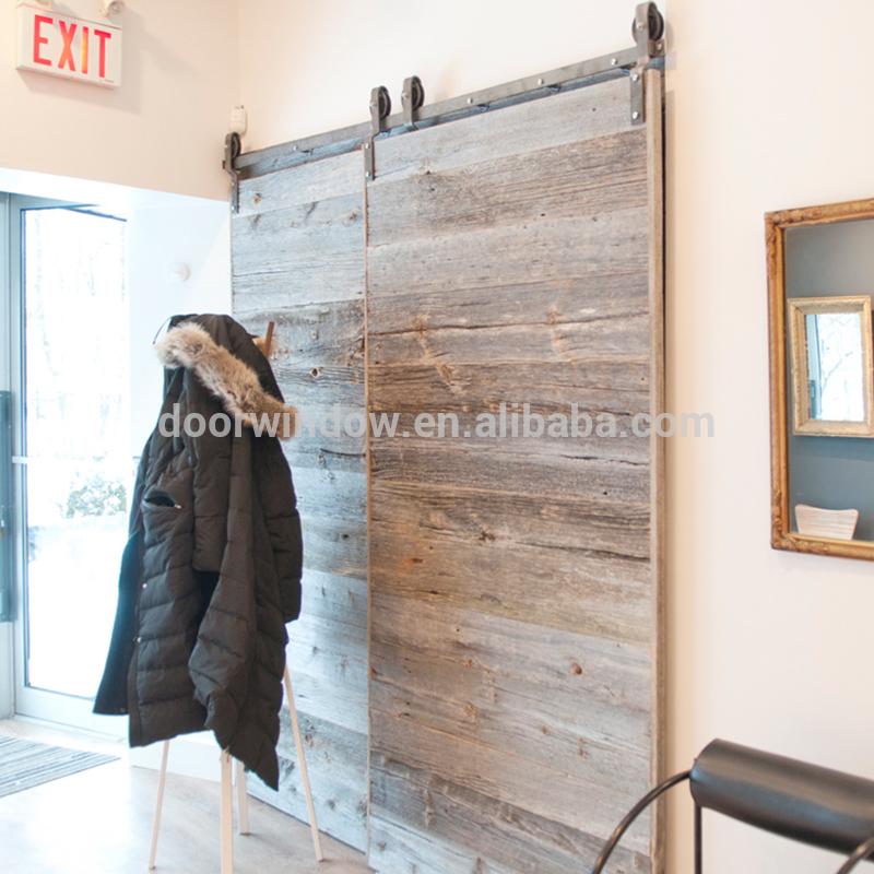 DOORWIN 2021Old knotty alder pine larch wooden door slats designs by-passing sliding barn door with heavy track by Doorwin